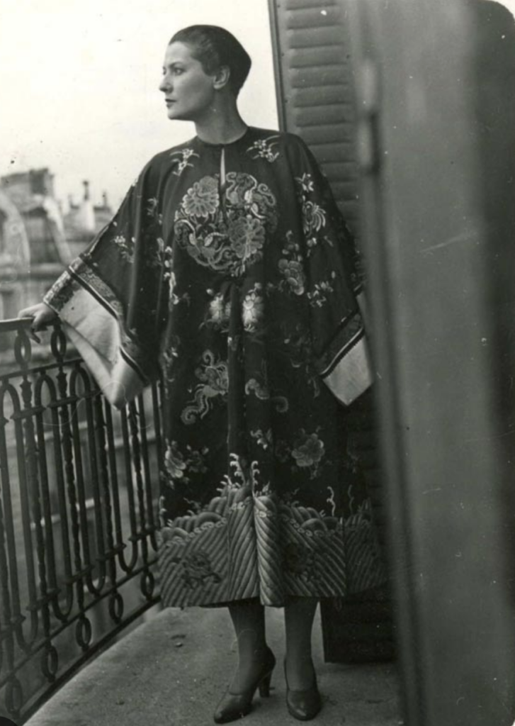 Suzanne Belperron à son balcon à Parisvêtue d’un kimono de soie brodée © Archives Olivier Baroin, Paris.